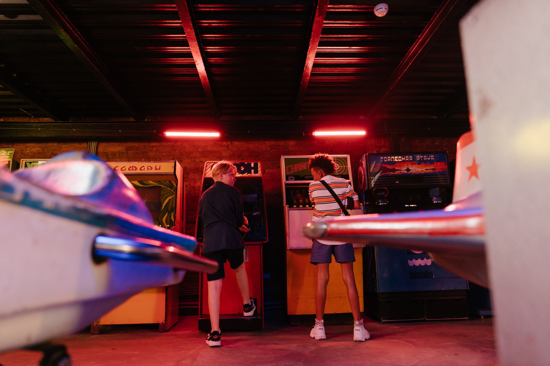 Visitors enjoying arcade games above a red carpeted aisle.