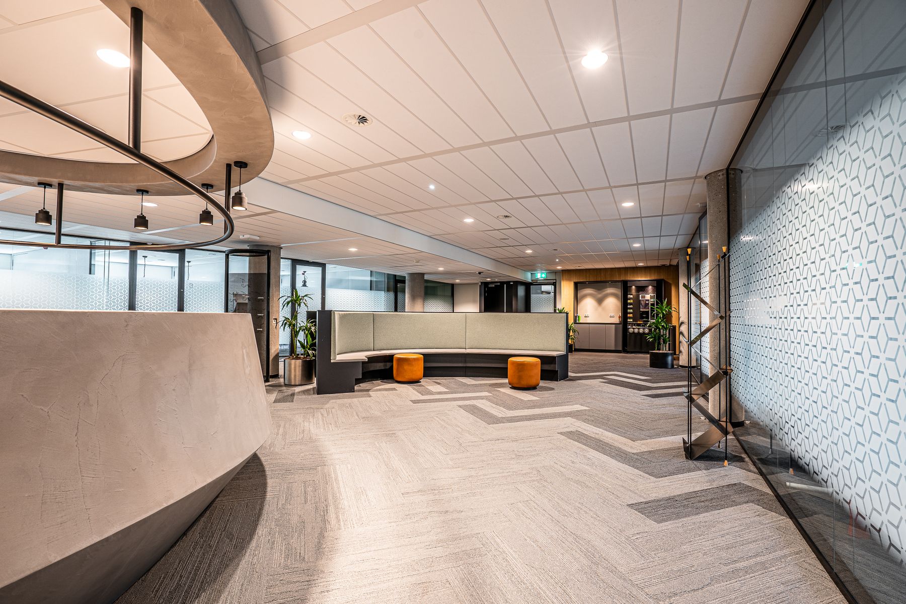 A carpeted commercial reception area with upholstered seating and warm lighting.