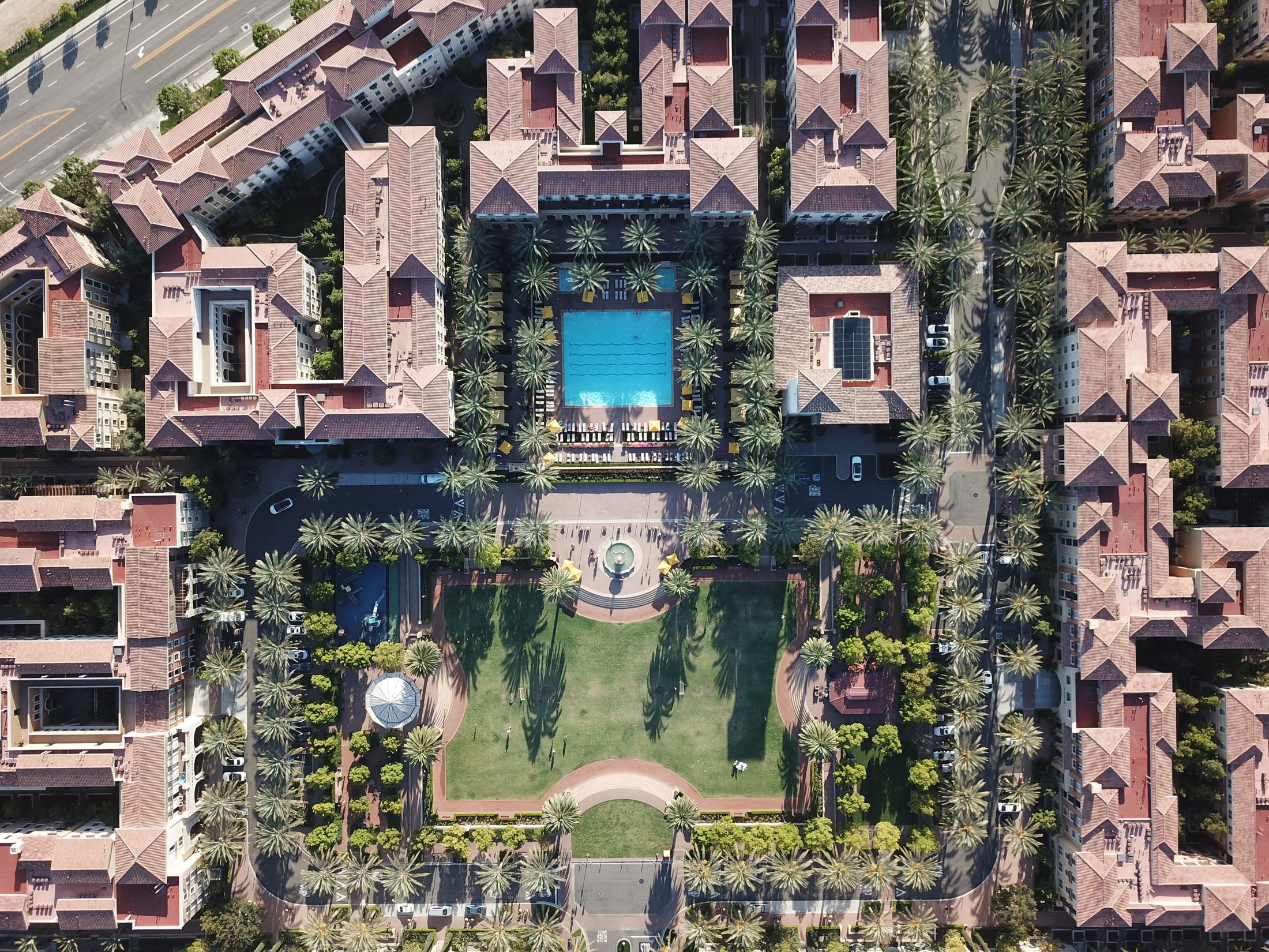 An Irvine apartment community with palm-lined shared grounds, a courtyard and a pool.